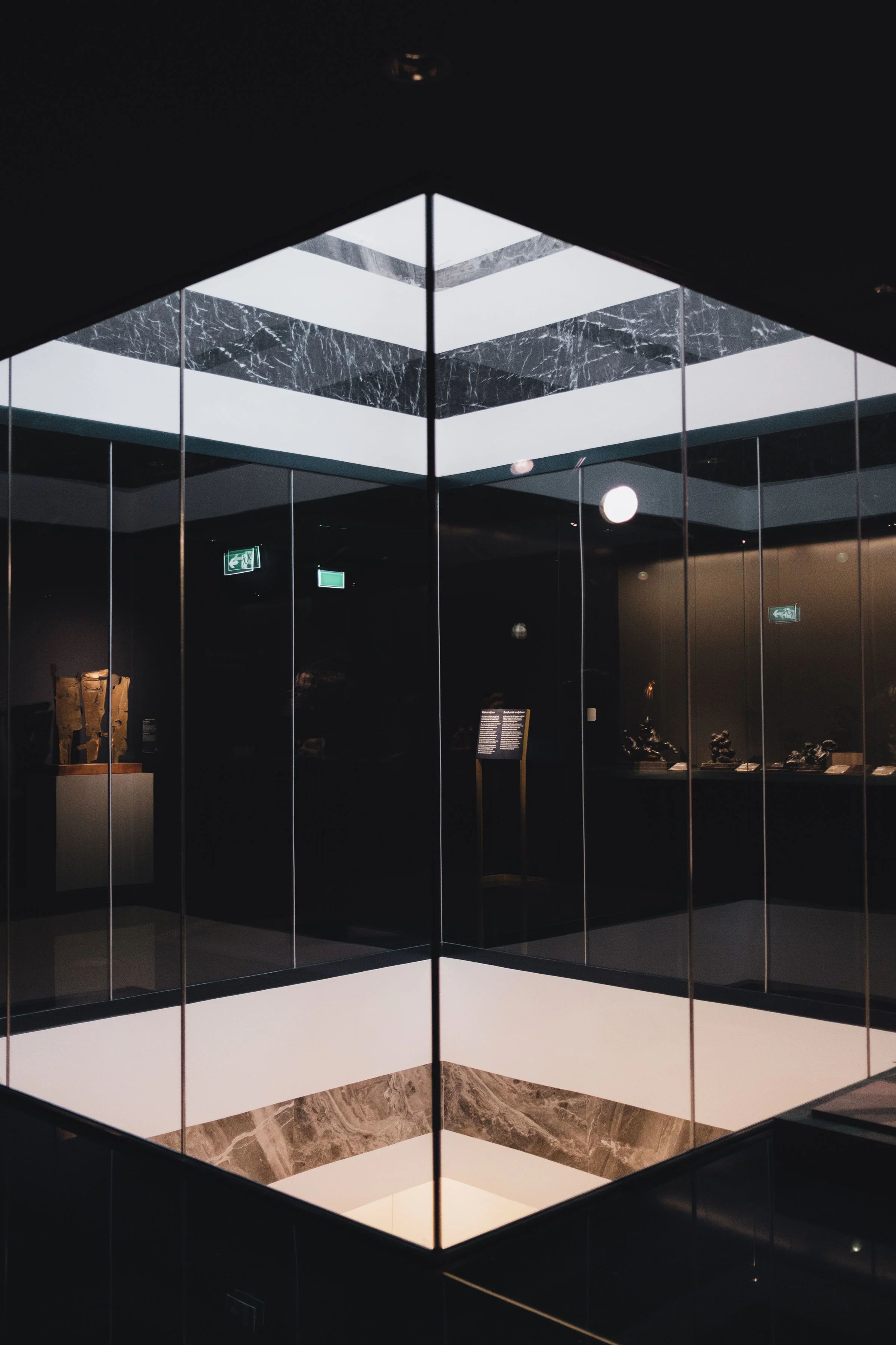 Glass atrium in a dimly lit gallery exhibition space